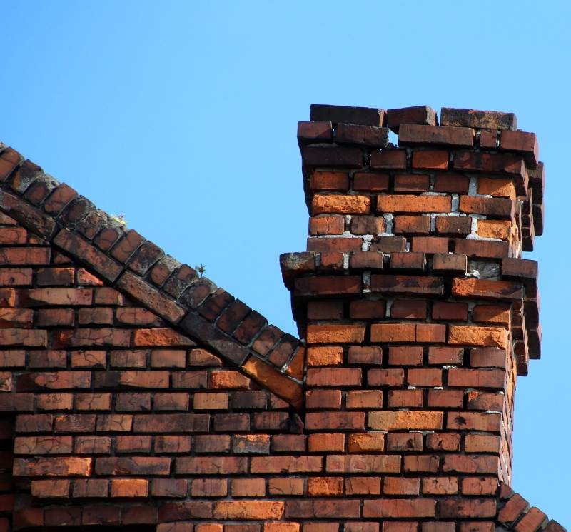 Signs Your Lowell Home Needs a Chimney Inspection Damaged chimney on an Lowell home showing cracks and missing mortar